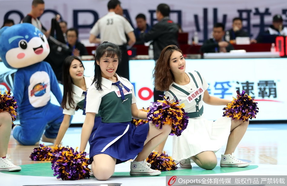 镜头拉近，这位篮球宝贝正在展现迷人的微笑，她随着音乐轻轻摆动手臂，流苏耳饰随之摇曳，在灯光下显得既干练又妩媚，尽显东方女性的独特魅力。