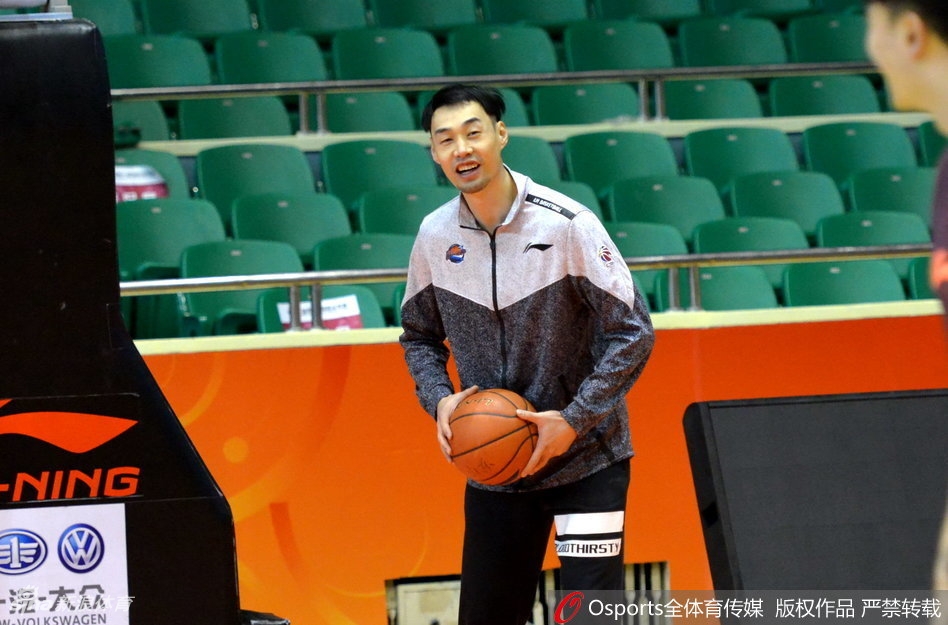 尽管只是坐在场边观看，但哈达迪高大的身影在训练馆灯光下投射出长长的影子，他紧握水瓶的姿势显得有力，仿佛随时准备起身为队友加油鼓劲，心始终与球队连在一起。