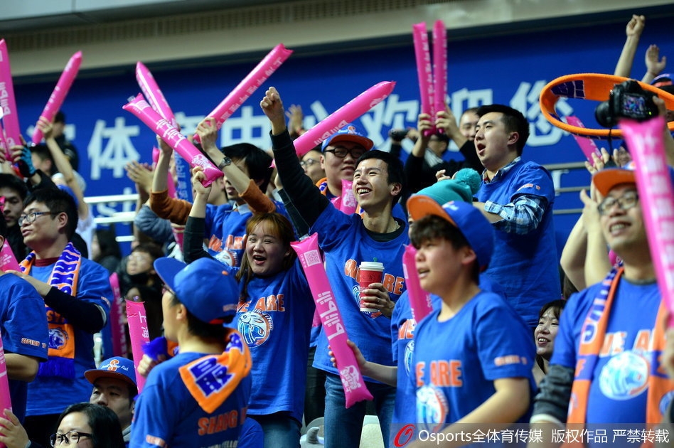 一位戴着眼镜的斯文男球迷被镜头捕捉，他手中的助威牌上画着一个可爱的漫画版丁彦雨航，旁边配文'不管在哪队，都是中国骄傲！'，简单的文字却表达了球迷对于中国篮球人才的珍视与爱护。