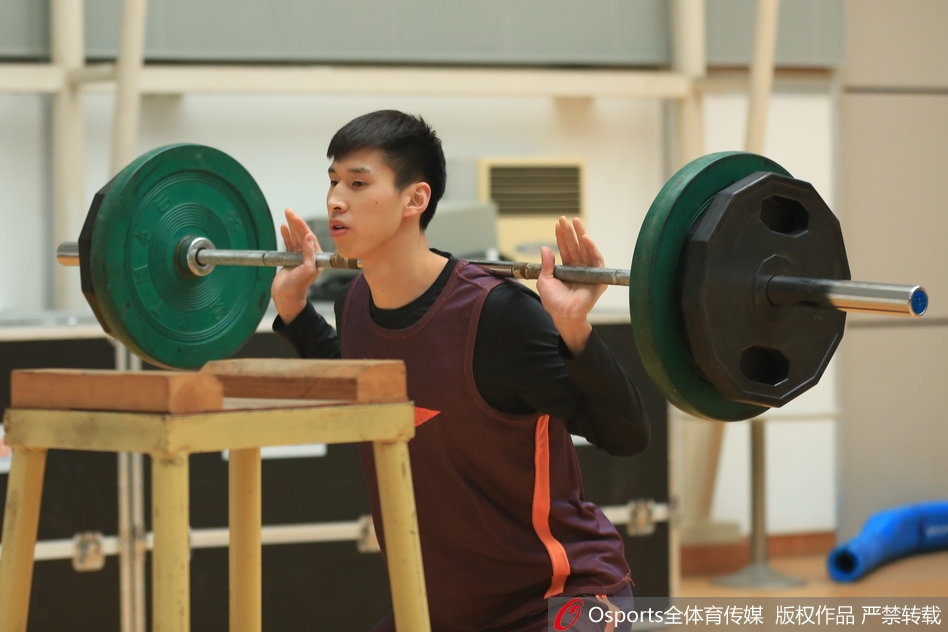 训练馆内，灯光如昼，高大的许钟豪手持专业录音笔，俯身凑向王治郅，眼神里满是好奇与敬意，仿佛要从这位老大哥口中挖出取胜的秘籍。