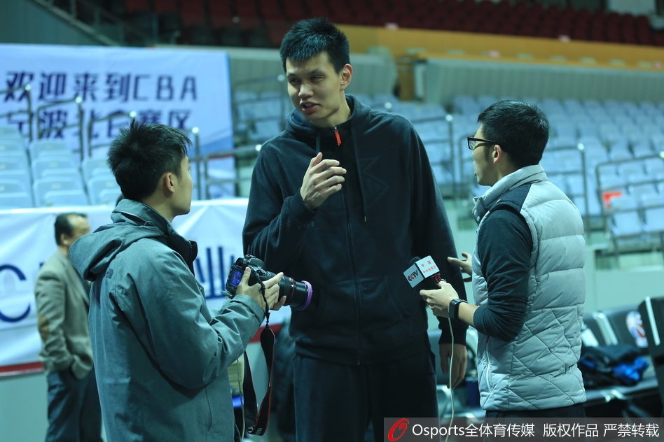 全体队员围成圆圈，将王治郅簇拥在中间，大家拳头碰在一起，齐声高喊加油，许钟豪站在大郅身旁，手臂高举，脸上洋溢着团队凝聚力的坚毅。