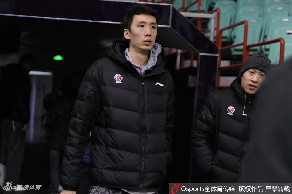 镜头拉近，可以看到哈德森眼神专注地倾听布鲁克斯说话，而身材高大的巴斯则微微低头，三人脸上都带着放松的神情，背景是肯帝亚队训练馆内忙碌的球员们。