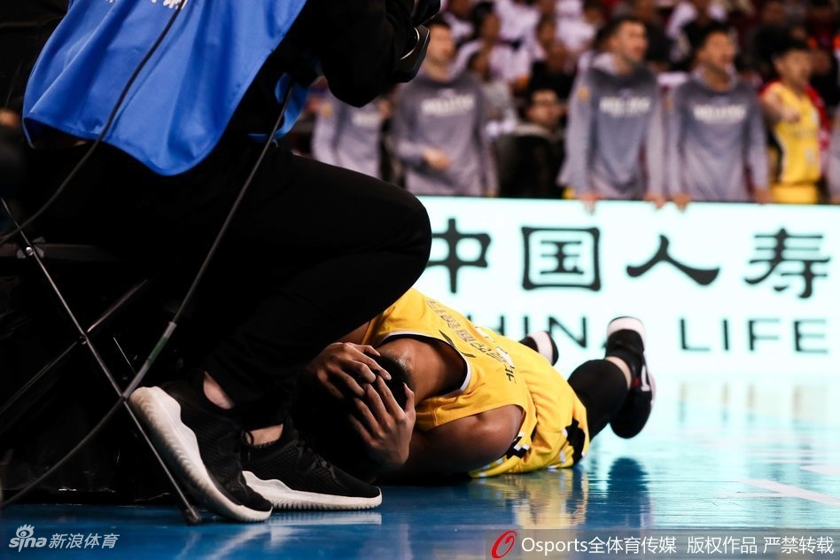 突破上篮后的贺希宁重摔倒地，表情痛苦地蜷缩在底线附近，常林从他身边跨过准备发球。