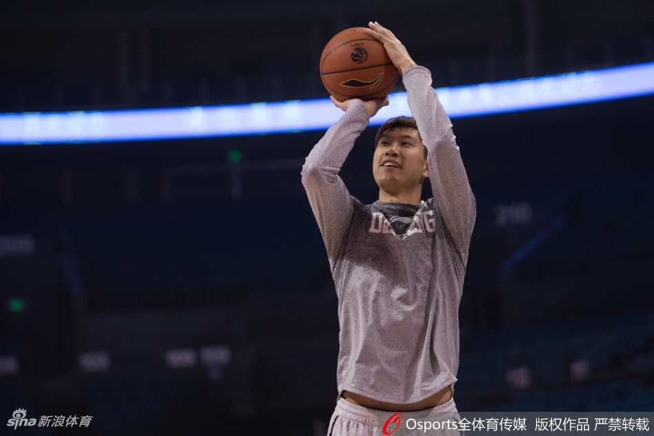 郭一飞在三分线外自信出手，篮球在空中划出完美弧线，背景是虚化的看台座椅，整个画面充满了静止的张力。