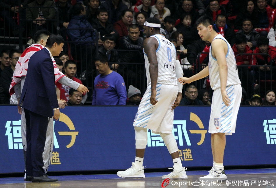 队医紧急蹲在布拉切身边进行初步诊断，而布拉切双手抱头，巨大的身躯横躺在地板上，显得那样无助，周围的北京首钢球员也纷纷驻足观望。