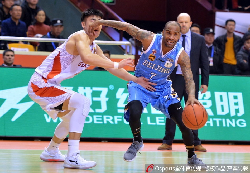 易建联在三人合围中奋力跃起，犹如鹤立鸡群，摘下关键的前场篮板，眼中满是对胜利的渴望。