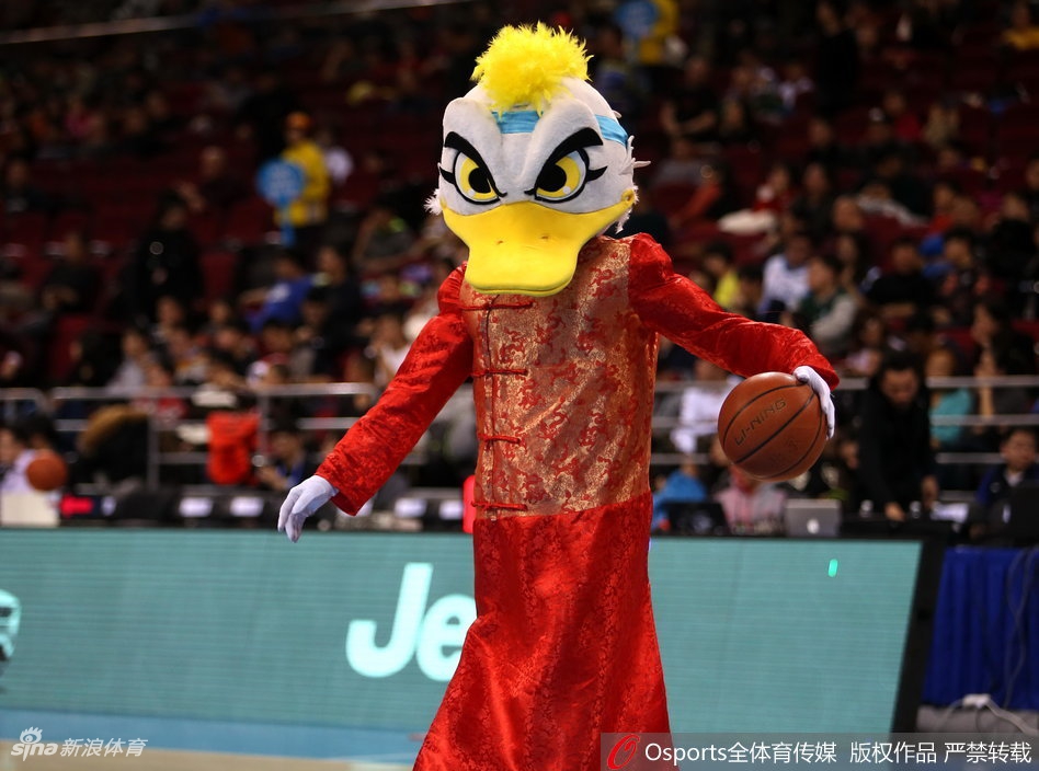 霹雳鸭套上了肥大的财神爷戏服，脸上贴着大胡子，手里捧着一个巨大的金色元宝，在场地中央扭动身体，仿佛在向四周抛洒着财运与福气。