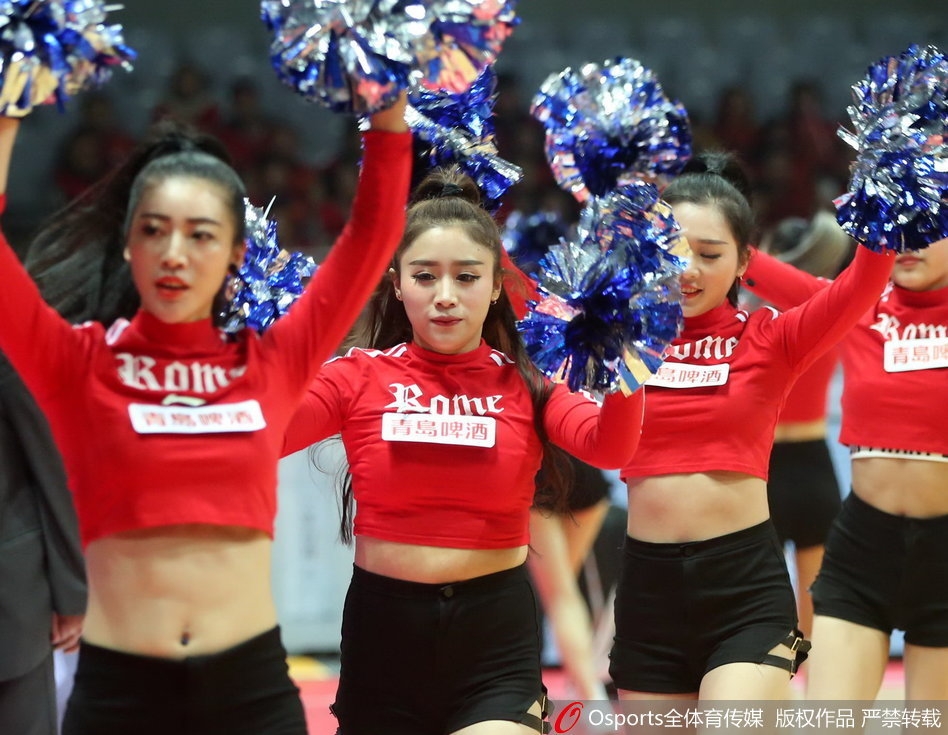 一名小宝贝拿着比自己小脸还大的迷你篮球，模仿着场上运动员的动作准备投篮，样子十分俏皮可爱