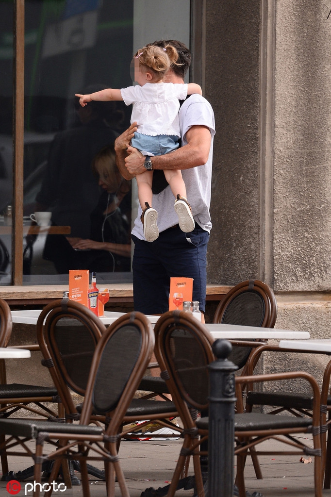 安娜牵着两个女儿的手走在前面，莱万则提着大包小包的物品跟在身后，眼神紧紧锁定着前方的三个背影，这一家子的背影杀充满了生活气息。