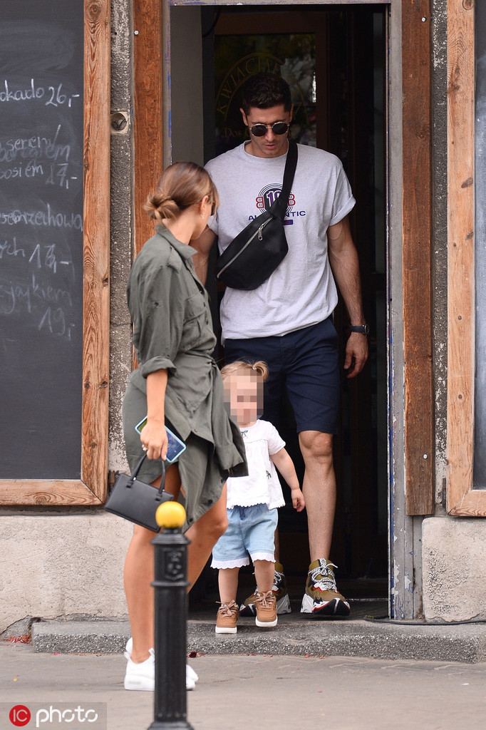 莱万单膝跪地，耐心地为女儿整理衣物，这细心的一幕与他进球后怒吼的霸气形象形成鲜明对比，父爱在此刻显得格外具体。