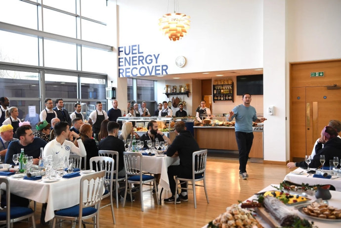 一张全景图展示了整个餐厅的热闹景象，几乎所有人都离开了座位，围在一起高声谈笑，圣诞彩带和气球点缀其间，宛如一个大家庭的团圆饭。