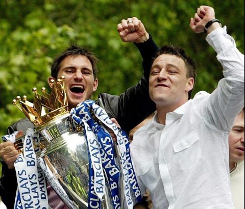 特里在场边神情专注，紧身运动衣外套着简单的T恤，正低头在战术板上奋笔疾书，仿佛一位运筹帷幄的将军。