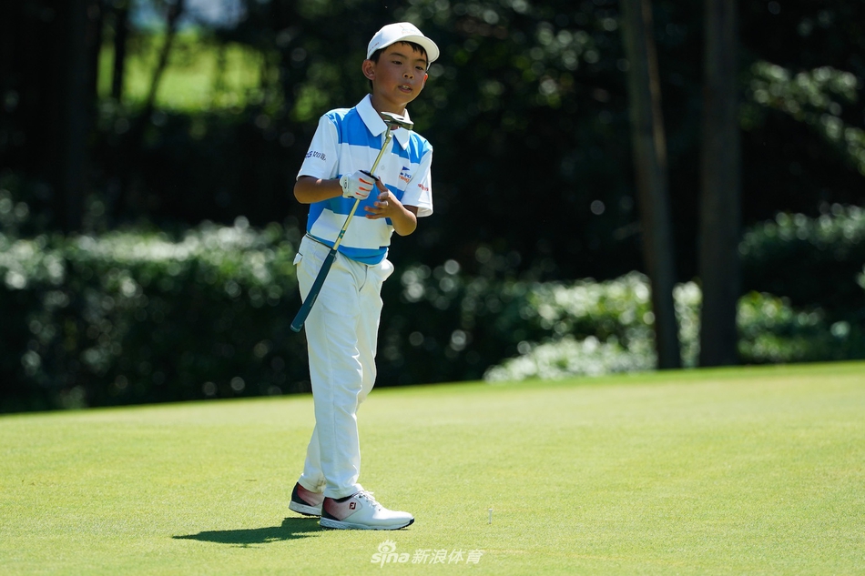 小选手在沙坑中成功击出救球，沙尘飞扬的瞬间，他身体保持完美的平衡，目光锐利地望向果岭。