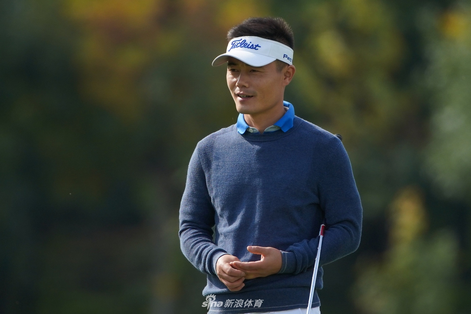 杜墨含与球童在开阔的球道上仔细研究击球路线，远处青山如黛构成绝美背景