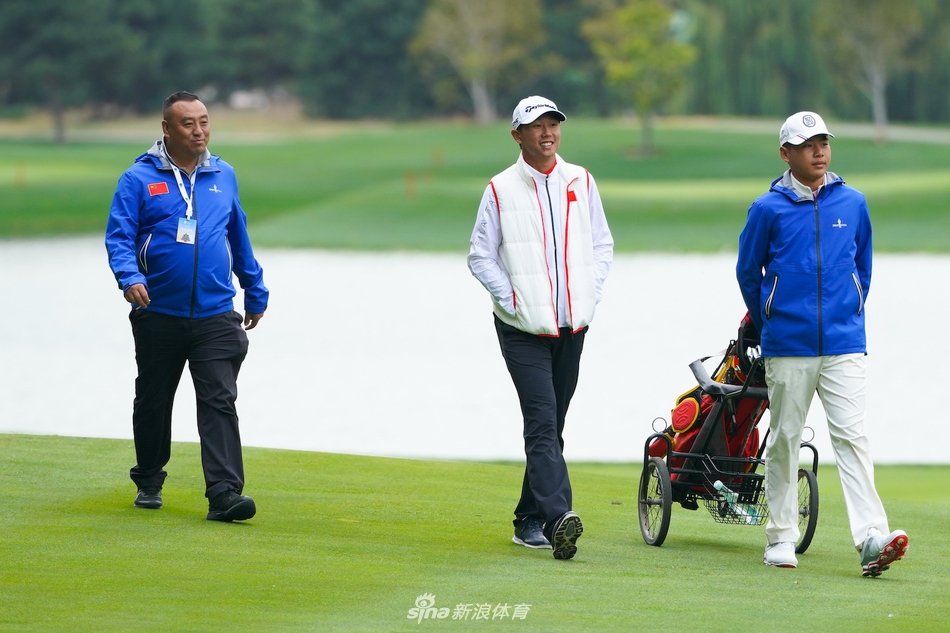 刘艳与杜墨含在练习果岭上相视而笑，轻松氛围中透露出队友间的深厚情谊