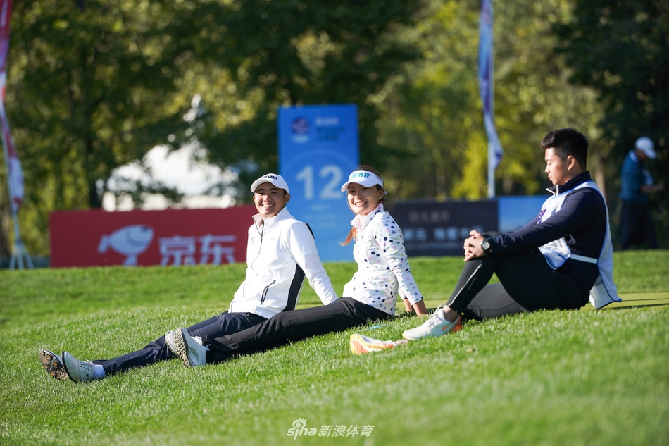 肖博文全力挥杆，身姿如满弓，球杆划破空气，背景是丽宫球场辽阔的天空与远山。