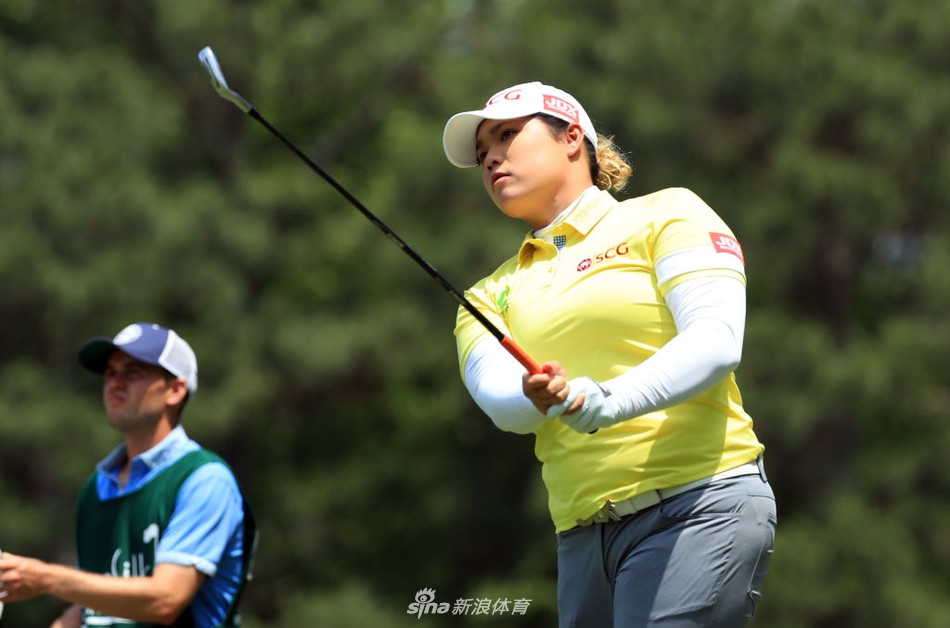 美国球员莱克西·汤普森凝视球路，湛蓝天空下她坚定的侧影与宽阔的球道构成一幅竞技画卷。