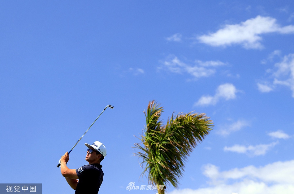 希格与竞争对手在记分处确认成绩,气氛紧张而专注,电子记分牌清晰显示着领先的杆数。