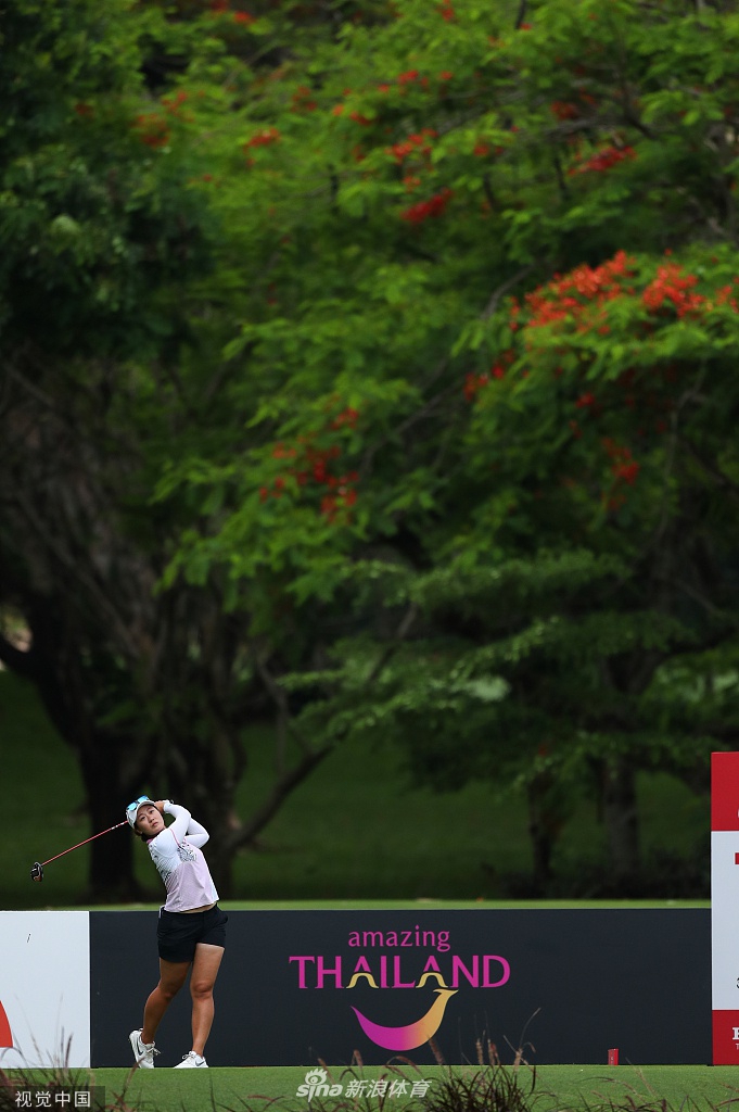 何沐妮在观众的注视下准备推杆，阳光下身影坚定