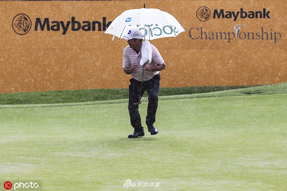 比赛暂停期间，大雨如注，空旷的第18洞球道和果岭上积水反射着天光，场面一片静谧。