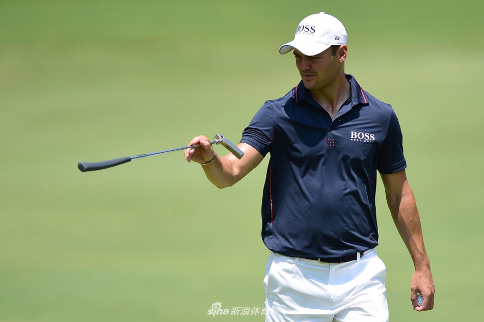 球员在沙坑中救球，沙砾飞扬，瞬间捕捉到高尔夫力量与技巧结合的美感。