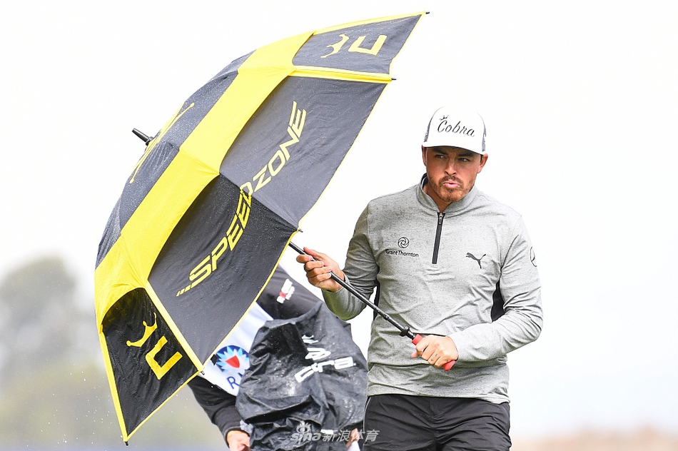 乔丹·斯皮思在潮湿的沙坑中救球，沙粒与水花混合飞溅，展现逆境中的技术较量。