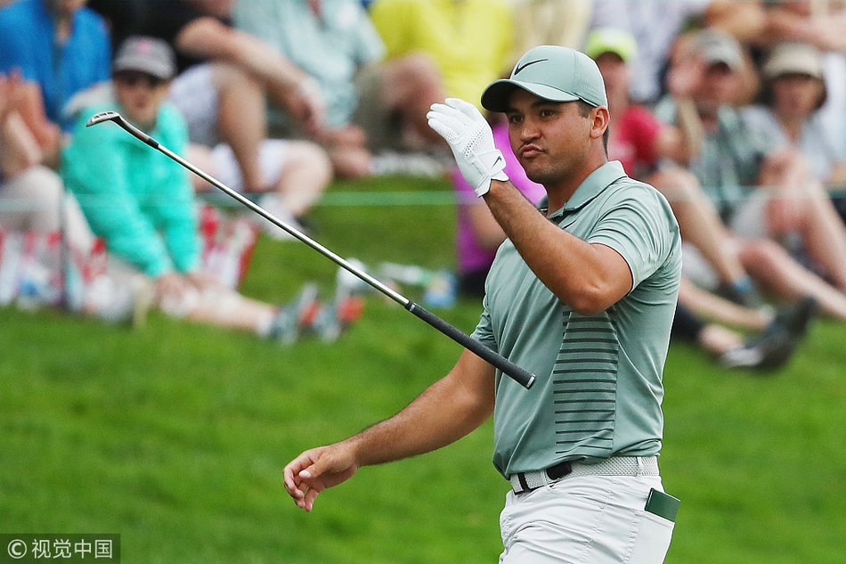 沃森高举旅行者锦标赛冠军奖杯，奖杯在聚光灯下璀璨夺目，象征着无上的荣耀。