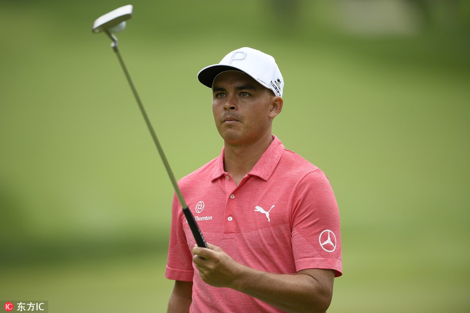 瑞奇·福勒在配对赛中潇洒挥杆，身姿舒展，与身后郁郁葱葱的林木构成一幅动感画面。