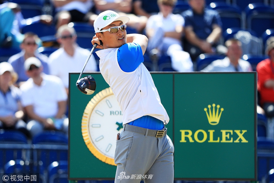 卡诺斯蒂林克斯球场全景，蜿蜒的球道与深色沙坑镶嵌在绿野之中，远处可见宁静的苏格兰小镇