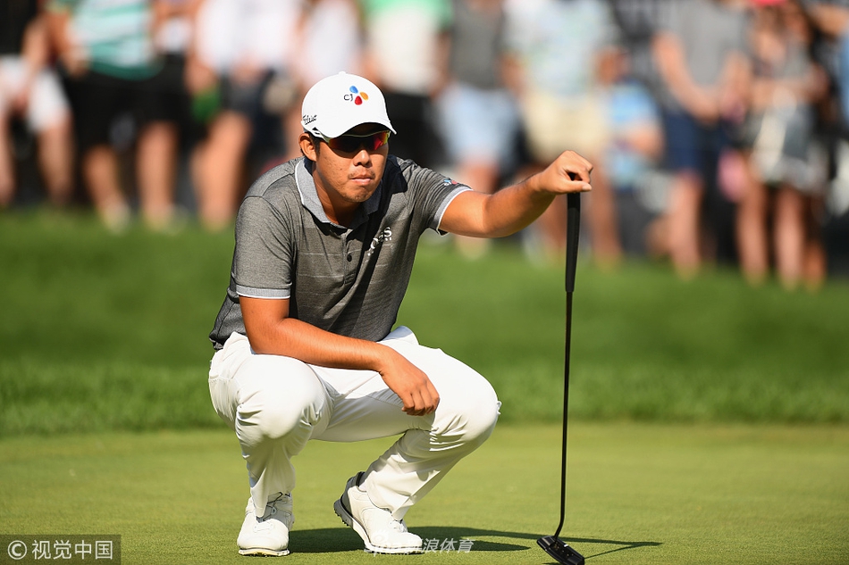 达斯汀·约翰逊向观众挥手致意，他身后的记分牌显示着决赛轮紧张的排名变化