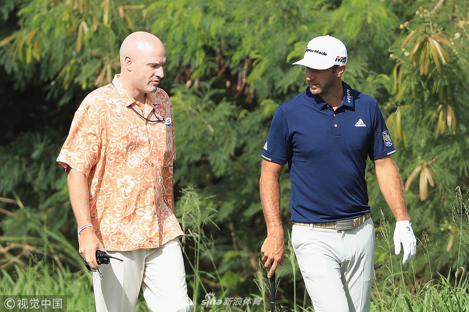 达斯汀-约翰逊正与裁判认真讨论球位规则，阳光下拉出长长的身影