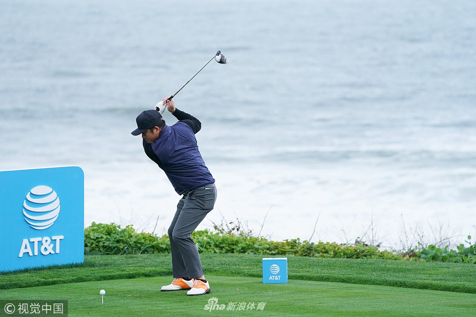 崔虎星挥杆至顶点瞬间，身体充分扭转，球杆高高指向蓝天，背景是圆石滩标志性的海岸线与丛林。