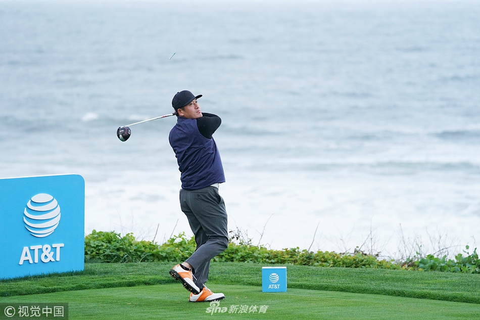 崔虎星向观众挥手致意，身后是圆石滩古朴的木制指示牌，展现了赛事轻松友好的氛围。