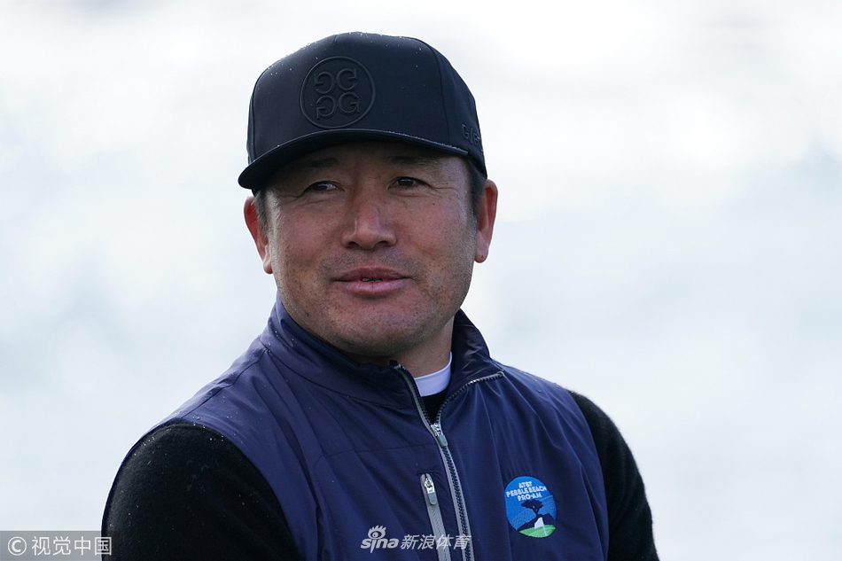 崔虎星在圆石滩第一洞发球台做预备动作，目光专注地凝视着远方的球道，海风吹动了他的衣角。