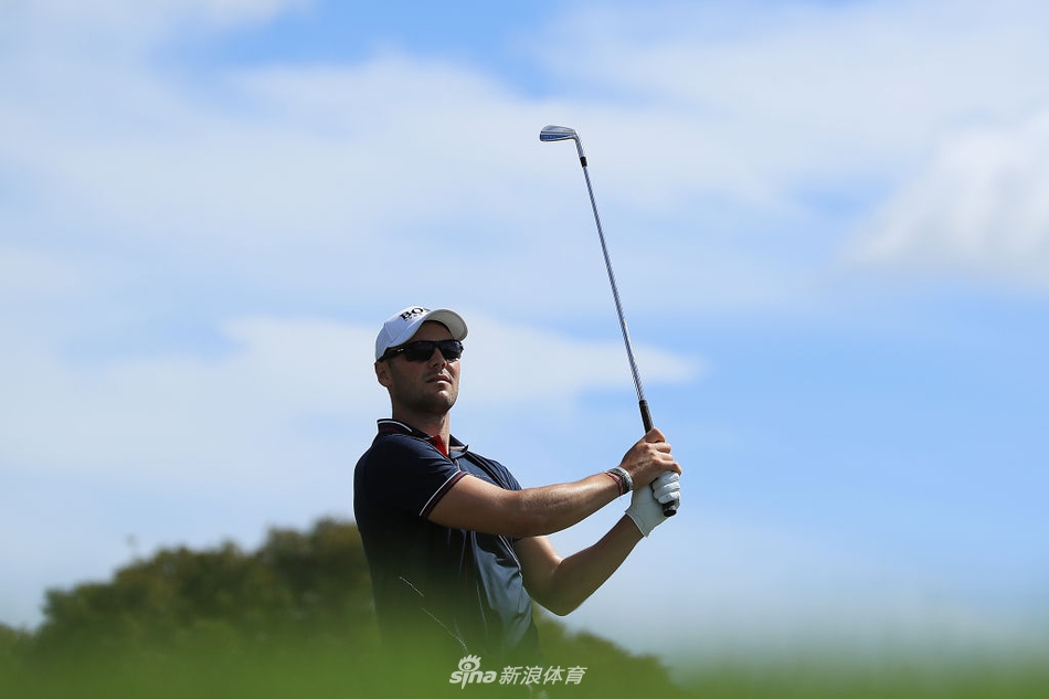 贾斯汀·托马斯在沙坑中救球，沙粒飞扬，展现高超的短杆技巧