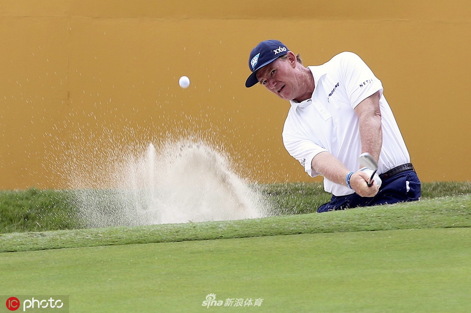 冠军斯科特·亨德高举马来亚银行锦标赛奖杯，笑容灿烂，背景中是见证了整个戏剧性下午的俱乐部会所。