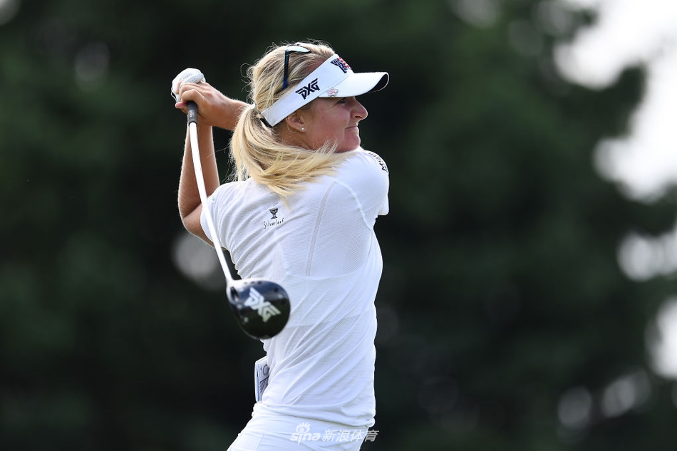 冯珊珊举起刺莓溪精英赛冠军奖杯，笑容灿烂，身后是洒满阳光的球场