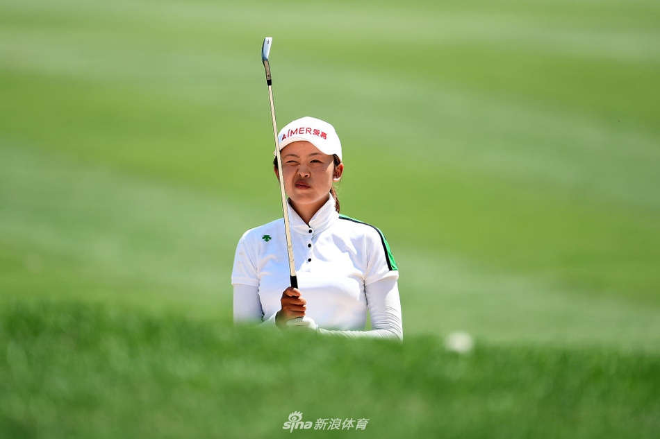 刘钰在刺莓溪球场果岭边专注观察推杆线路，眼神中透着坚定与自信