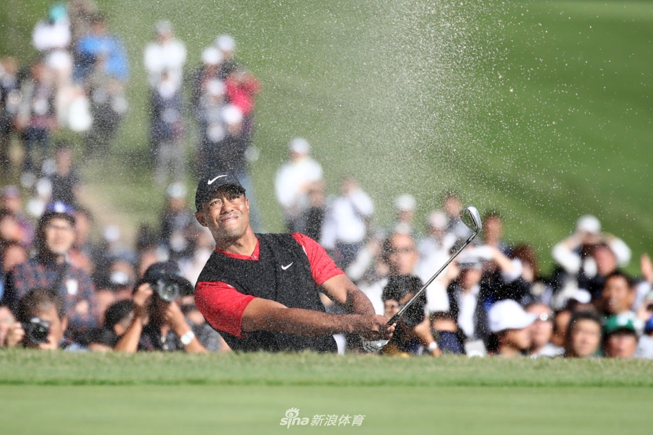 伍兹在沙坑中成功救球后，球童上前击掌庆祝，两人默契的合作是胜利的重要一环。