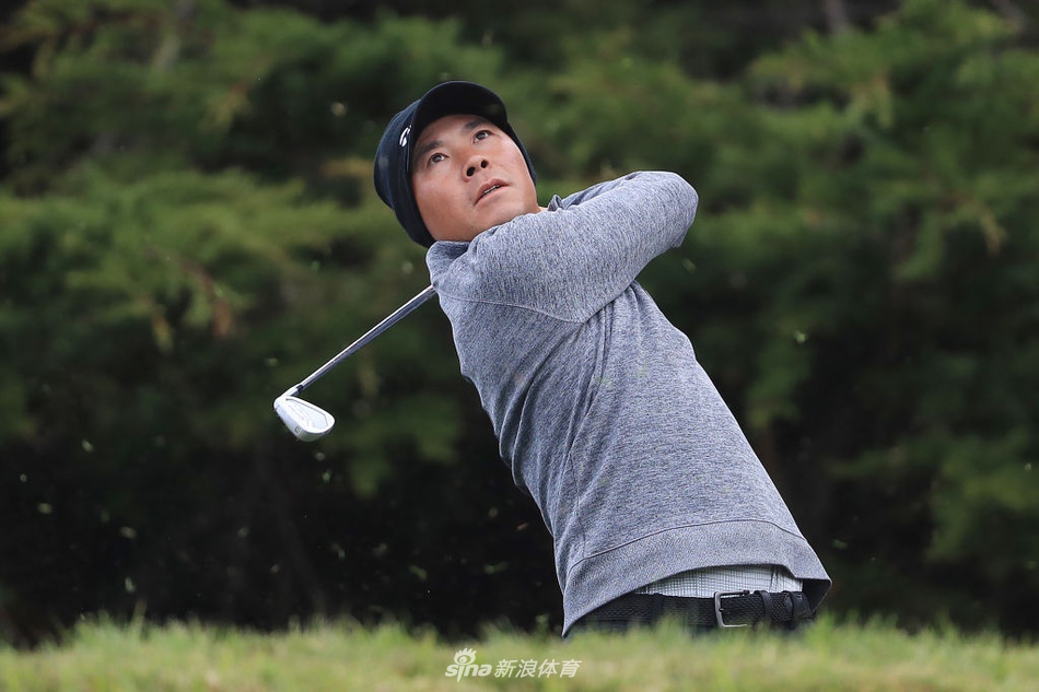 尼克·泰勒在强风中沉稳挥杆，眼神专注地望向果岭，诠释了冠军的坚韧与专注