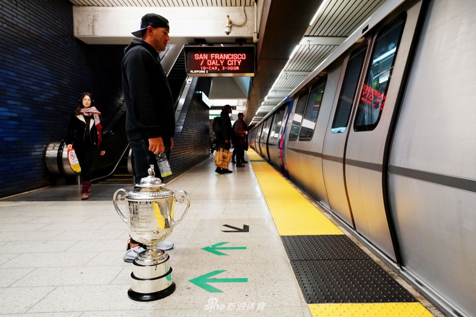 科普卡与奖杯的倒影清晰地映照在地铁光洁的车窗上，与窗外的都市繁华重叠，构成一幅虚实交织的梦幻画面