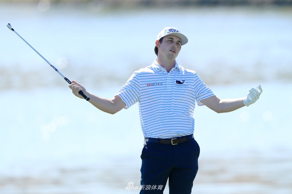 弗利特伍德全神贯注地凝视球道，强风吹拂着他的标志性卷发，背景是PGA全国度假村标志性的水障碍与棕榈树。