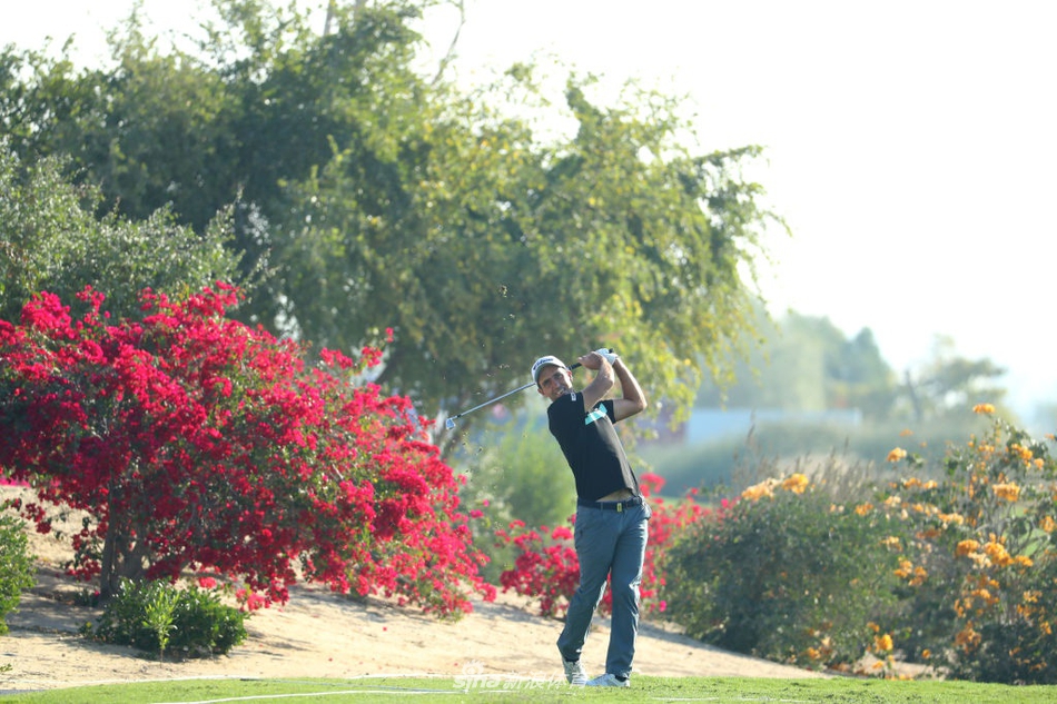 球员瓦里马奇在沙坑中救球，沙粒随杆头飞扬，瞬间展现了高尔夫运动力量与技巧结合的动态之美。