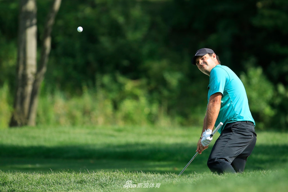 比赛球童正在为球员仔细擦拭高尔夫球，两人专注讨论策略，体现团队协作