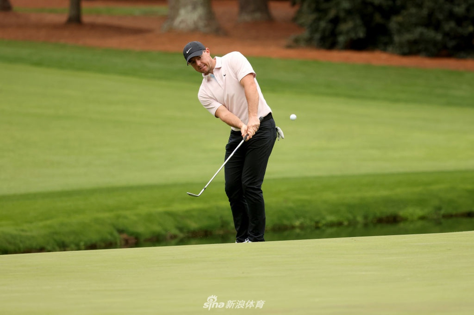 大师赛冠军松山英树面带谦和微笑，向观众致意，身后是沐浴在晨光中的静谧球场。