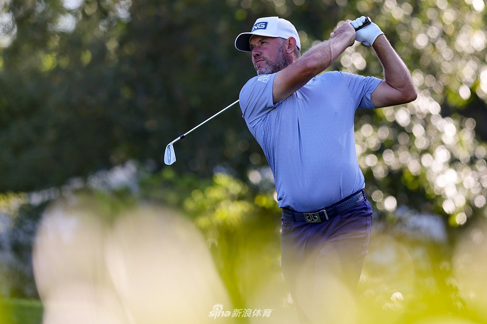 英格兰名将李·维斯特伍德在球员锦标赛次轮中，于发球台上沉稳挥杆，目光坚定地追踪小球飞行轨迹。