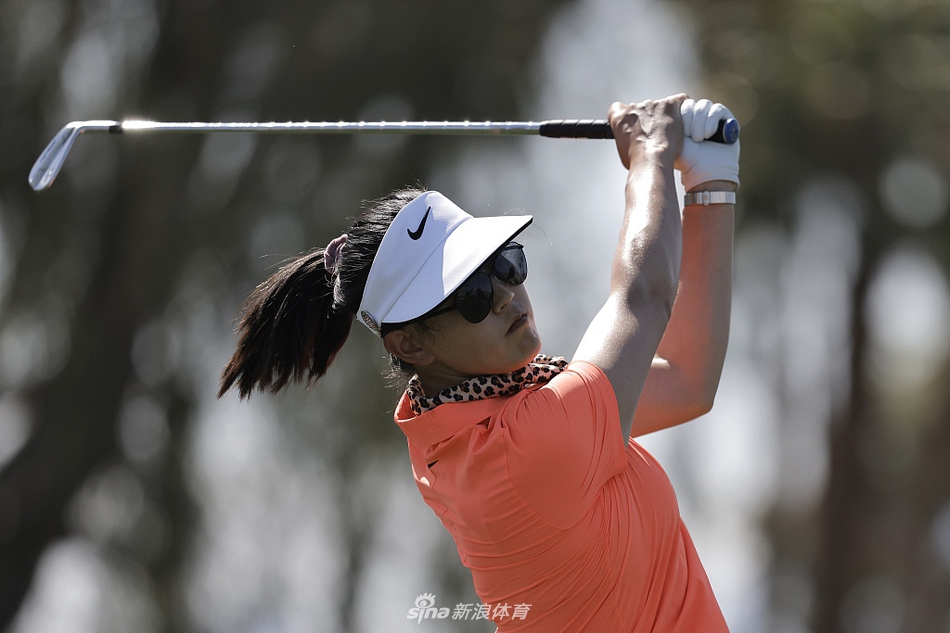 比赛进行中，球手在沙坑中救球，沙粒飞扬瞬间展现高尔夫运动的技巧与力量