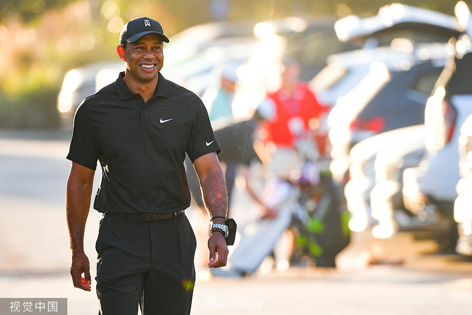 泰格·伍兹与儿子查理并肩走向发球台，两人步伐一致神情专注