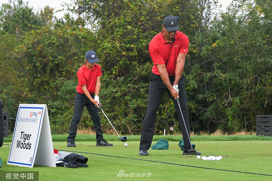 伍兹父子身着标志性周日红色战袍，在佛罗里达的阳光下并肩走向果岭，父亲的目光沉静，儿子的步伐充满活力。