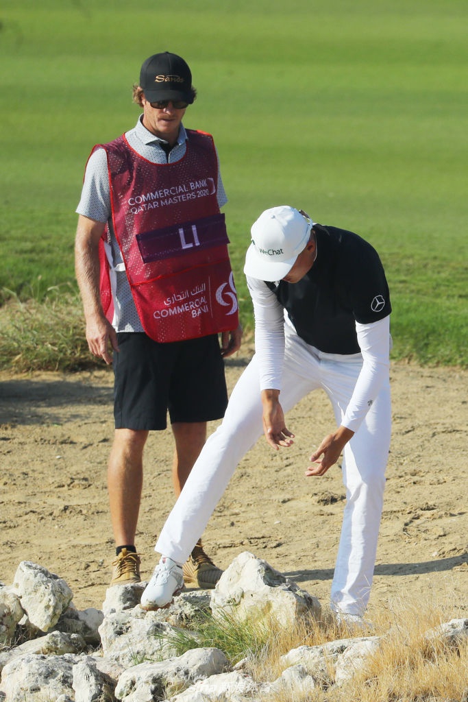 夕阳余晖下，李昊桐背对镜头走向下一个洞，身影在球道上拉长，透露出孤独与坚韧。